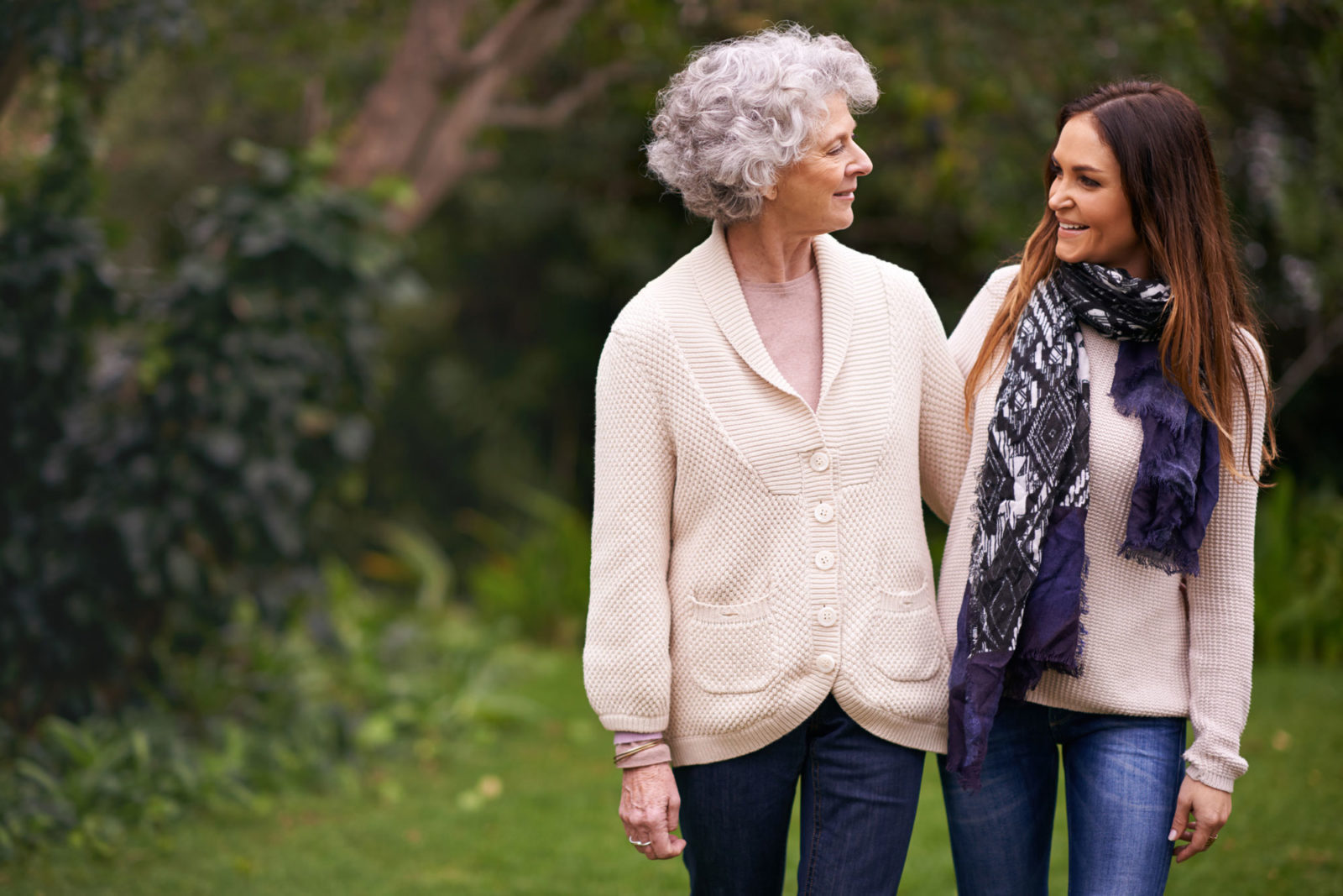 elderly mother and daughter walking in a park